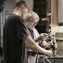 Vorarbeiter zeigt Lehrling die Verwendung eines Werkzeug